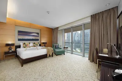 a hotel room with a bed and a desk and a television at Maison Privee - Fabulous Studio with Direct Burj Khalifa Views in Dubai
