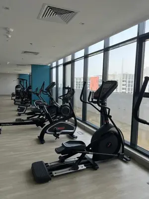 a row of exercise bikes in a gym with windows at Luxury Studio Brand New with HighEnd Furnishings in Dubai
