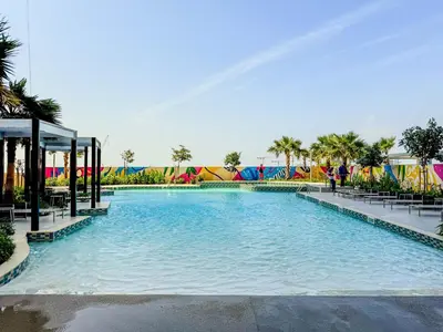 a large swimming pool with tables and chairs in a resort at 35th Floor Luxury 2 BR with Stunning Views in Dubai