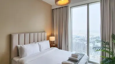 a bedroom with a white bed and a large window at Chic New 2BR Dubai Creek Gate by Tanami Holiday Homes in Dubai