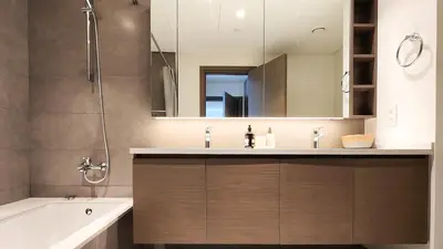 a bathroom with a sink and a tub and a mirror at Chic New 2BR Dubai Creek Gate by Tanami Holiday Homes in Dubai