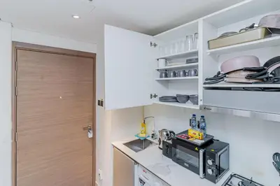 a kitchen with white cabinets and a counter top at Elegant Studio Stay I Pool, Gym & Parking in Dubai