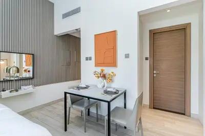 a bedroom with a table and a bed and a mirror at Elegant Studio Stay I Pool, Gym & Parking in Dubai