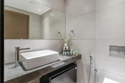 a bathroom with a white sink and a shower at Elegant Studio Stay I Pool, Gym & Parking in Dubai