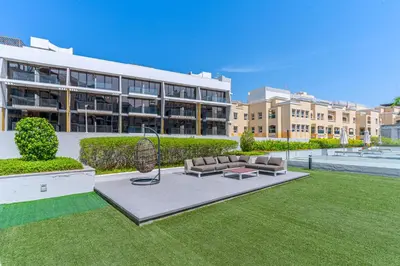 a building with a couch and a bench in the grass at Elegant Studio Stay I Pool, Gym & Parking in Dubai
