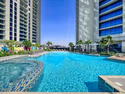 a swimming pool with blue water in front of buildings at GuestReady - Contemporary studio in Business Bay in Dubai
