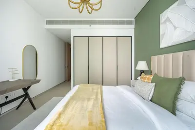a bedroom with a large bed with a desk and a mirror at GuestReady - Above the clouds in Dubai Marina in Dubai