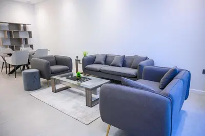 a living room with blue couches and a table at Super Luxurious! New 2BR in Jumeirah Garden City in Dubai