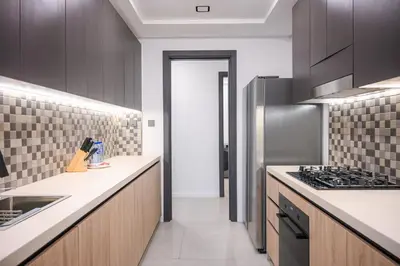 a kitchen with wooden cabinets and a stove top oven at Super Luxurious! New 2BR in Jumeirah Garden City in Dubai