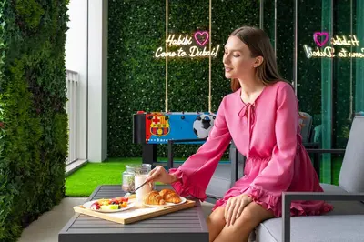 a woman sitting on a table with a tray of food at Amazing Patio Experience - Best Burj Khalifa View in Dubai