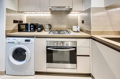 a kitchen with a stove and a washing machine at Sobha Creek Vistas, Sobha Hartland, MBR City, Dubai in Dubai