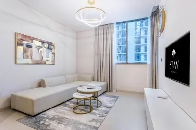 a living room with a couch and a table at STAY BY LATINEM Luxury 1BR Holiday Home CV A1507 near Burj Khalifa in Dubai