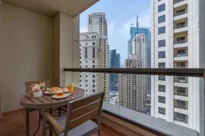 a table with a plate of food on a balcony at Amazing Seaview Prime Location Upgraded in Dubai