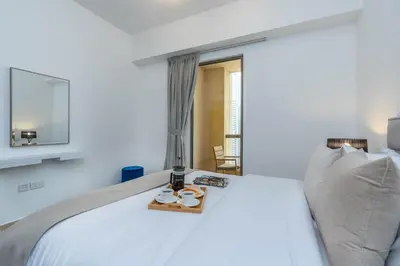 a bedroom with a white bed with a tray with sandals on it at Amazing Seaview Prime Location Upgraded in Dubai