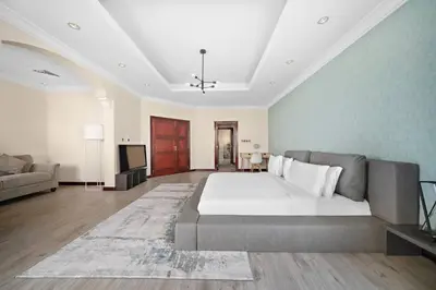 a large bedroom with a large bed and a couch at Beachfront Dubai Villa for 10 Guests with Full Kitchen & View in Dubai