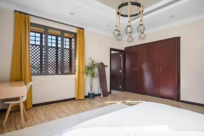 a bedroom with a bed and a desk and a chandelier at Beachfront Dubai Villa for 10 Guests with Full Kitchen & View in Dubai