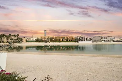 a view of a beach with a lighthouse in the distance at Beachfront Dubai Villa for 10 Guests with Full Kitchen & View in Dubai