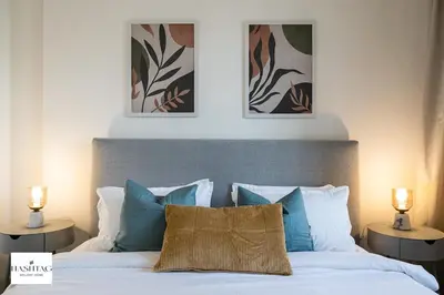 a bedroom with a bed with two pictures on the wall at Al Andalus D I Jumeirah Golf Estates in Dubai