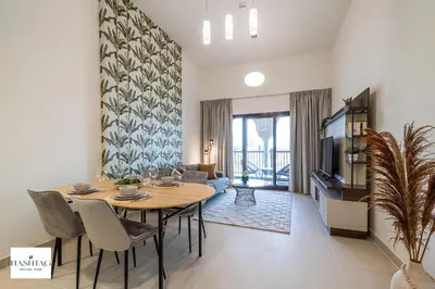 a dining room with a table and a living room at Al Andalus D I Jumeirah Golf Estates in Dubai