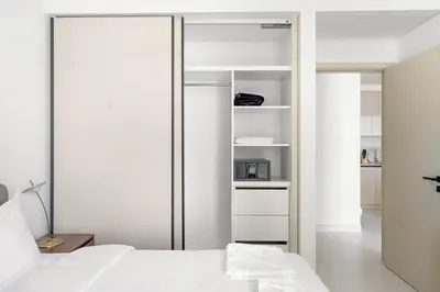 a bedroom with white walls and white furniture at Silkhaus Chic 1BDR in Exclusive Neighbourhood in Dubai