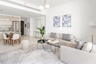 a white living room with a couch and a table at Silkhaus Chic 1BDR in Exclusive Neighbourhood in Dubai