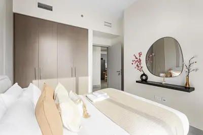 a bedroom with a white bed with a mirror at Silkhaus Chic 1 BDR In a New Tower In Downtown in Dubai