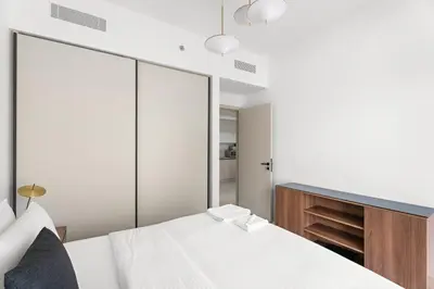 a bedroom with a white bed and a mirror at Silkhaus Partial Marina View 1BDR in Marina Vista in Dubai