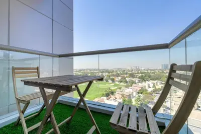 a table and two chairs on a balcony with a view at Luxury Studio - Golf Views - Sports City Dubai in Dubai