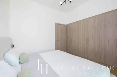 a bedroom with a bed with a wooden headboard at LUX The Dubai Hills Executive Suite in Dubai