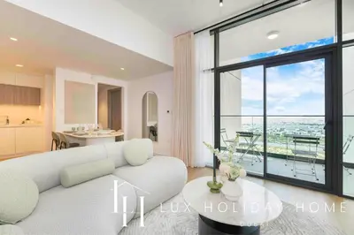 a living room with a white couch and a large window at LUX The Dubai Hills Executive Suite in Dubai