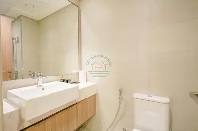 a bathroom with a sink and a toilet and a mirror at Azizi Riviera 18 in Dubai