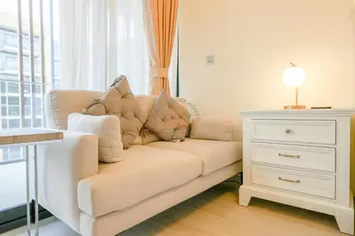 a couch with pillows on it next to a dresser at Azizi Riviera 18 in Dubai
