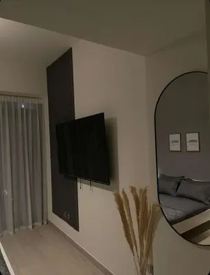a room with a mirror and a flat screen tv on the wall at Chic apartment, Maydan Riviera Dubaï in Dubai