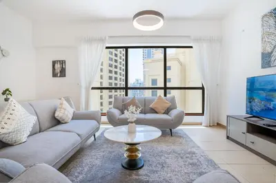 a living room with a couch and a tv at RH- Walk to JBR beach & Tram, Comfortable 02BR in Dubai