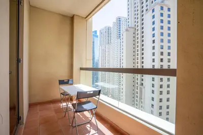 a room with two chairs and a table and a large window at RH- Walk to JBR beach & Tram, Comfortable 02BR in Dubai
