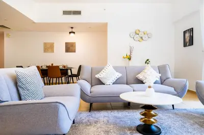 a living room with couches and a table at RH- Walk to JBR beach & Tram, Comfortable 02BR in Dubai