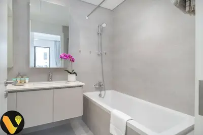 a white bathroom with a tub and a sink at Vogue Creek Harbour Breeze Creek Beach Waterfront Living Close to Downtown, Burj Khalifa and Dubai Mall, Two Bedroom apartment With Balcony and Private Manmade Beach, Access to all Amenities in Dubai