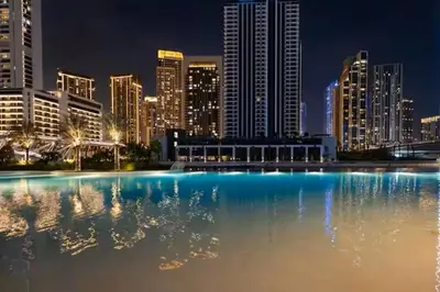 a large pool of water in front of a city at night at Vogue Creek Harbour Breeze Creek Beach Waterfront Living Close to Downtown, Burj Khalifa and Dubai Mall, Two Bedroom apartment With Balcony and Private Manmade Beach, Access to all Amenities in Dubai