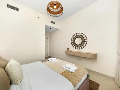 a white bedroom with a bed and a mirror at Sky High 2-Bedroom Apartment Stunning Opera & Downtown Views Opp Dubai Mall in Dubai