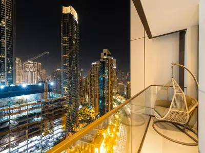 a balcony with a view of a city at night at Sky High 2-Bedroom Apartment Stunning Opera & Downtown Views Opp Dubai Mall in Dubai