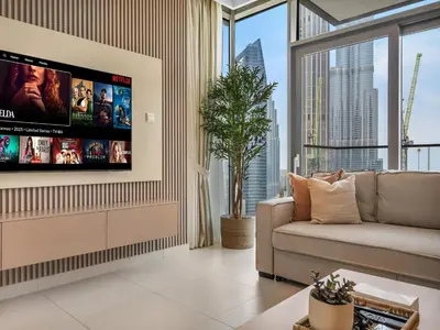 a living room with a couch and a flat screen tv at Sky High 2-Bedroom Apartment Stunning Opera & Downtown Views Opp Dubai Mall in Dubai