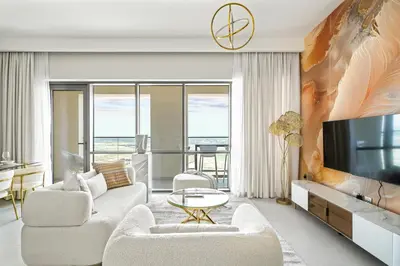 a living room with a couch and a tv at Vida Voyage - Vida Residences - Creek Harbour in Dubai