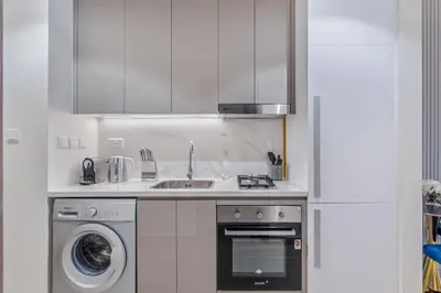 a kitchen with a sink and a washing machine at Lux-Furnished Stu Couple-Friendly Near Downtown in Dubai