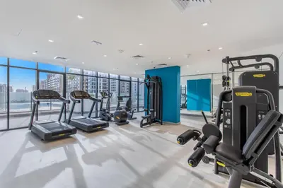 a gym with several treadmills and cardio machines at Lux-Furnished Stu Couple-Friendly Near Downtown in Dubai