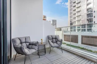two chairs and a table on a balcony at Lux-Furnished Stu Couple-Friendly Near Downtown in Dubai