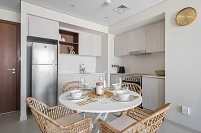 a kitchen with a white table and chairs at Harbour Oasis - Vida Residences - Creek Harbour in Dubai