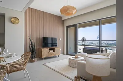 a living room with a television and a table and chairs at Harbour Oasis - Vida Residences - Creek Harbour in Dubai