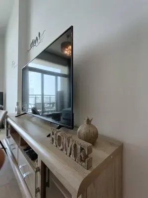 a mirror on top of a dresser in a living room at 1 Bed room - Azizi Daisy - Furjan in Dubai