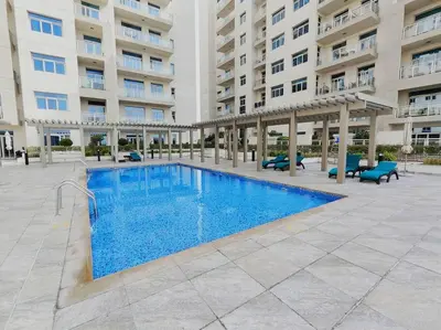 a large swimming pool in front of a building at 1 Bed room - Azizi Daisy - Furjan in Dubai