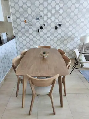 a wooden table and chairs in a room at 1 Bed room - Azizi Daisy - Furjan in Dubai